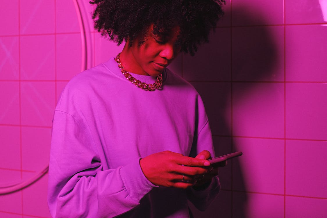 A person in a purple jumper looking at their phone.
