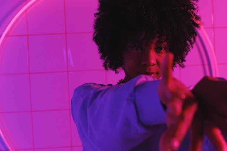 African American Woman Reaching Out Hands And Looking At Camera In Studio