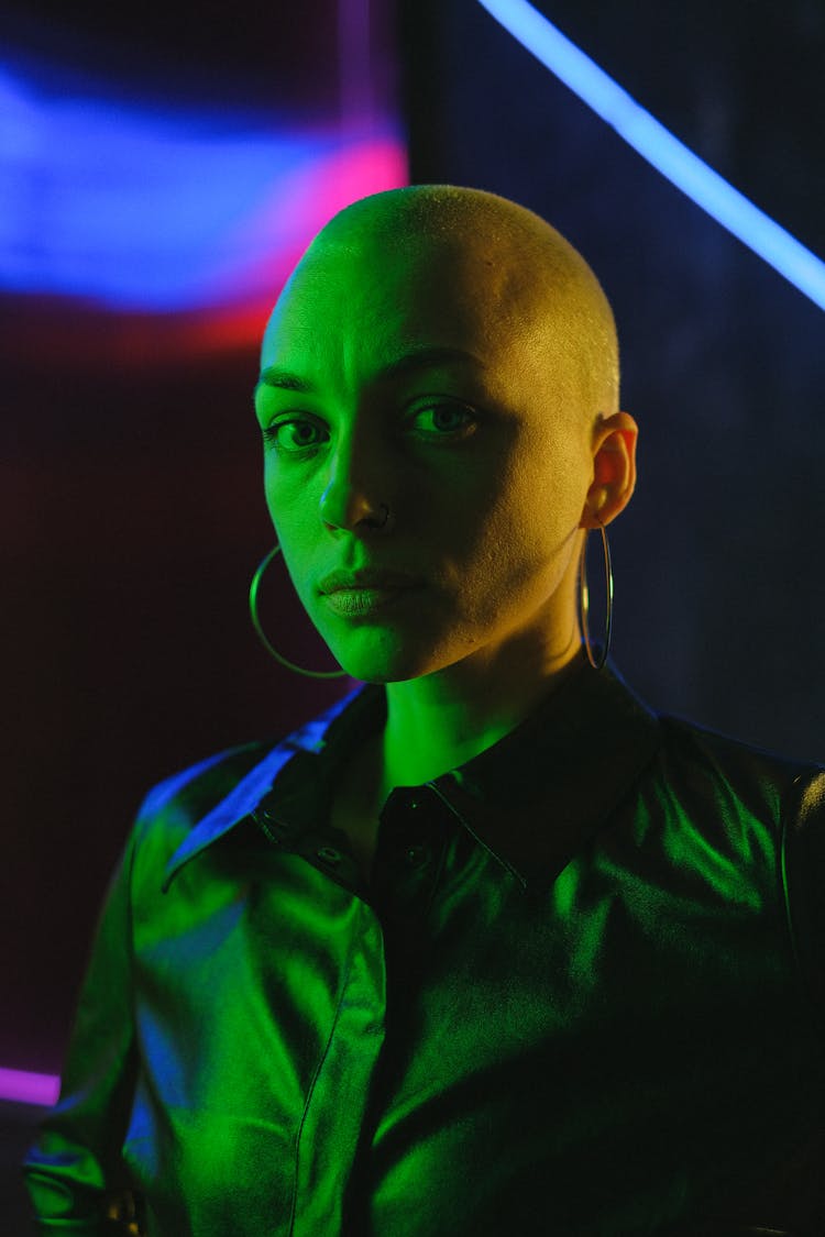 Unemotional Bald Woman In Neon Lights