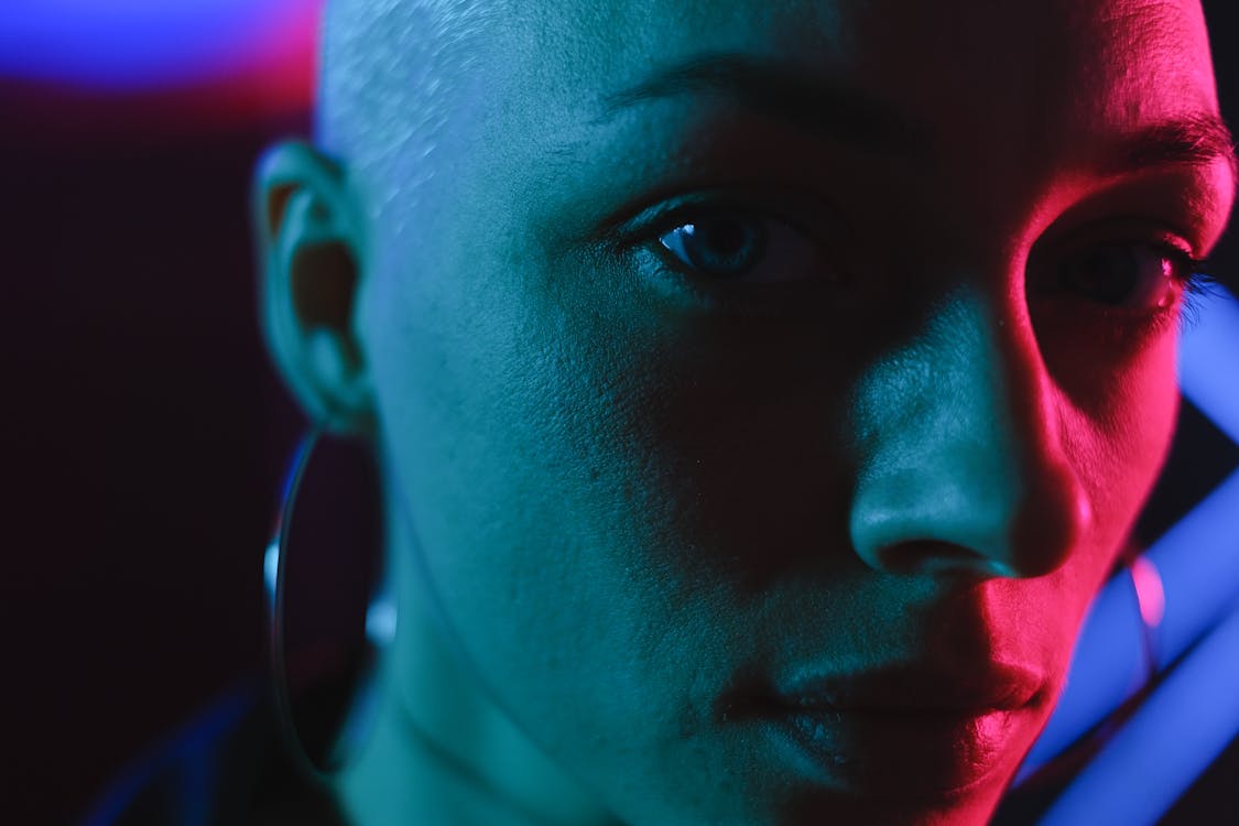 Crop bald woman in neon lights