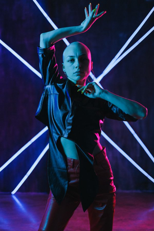 Portrait of dance director Maya Richardson lit by neon stage lights