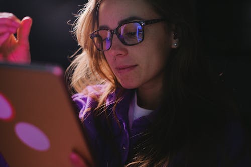 Young woman using tablet in dark room