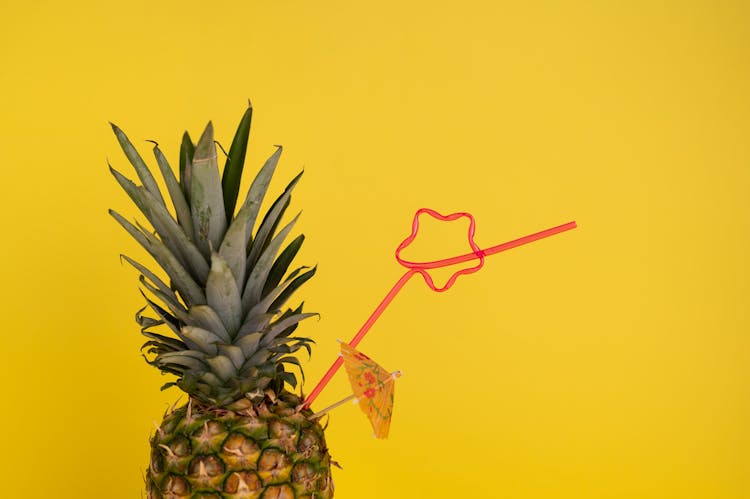 Pineapple With Cocktail Straw In Studio