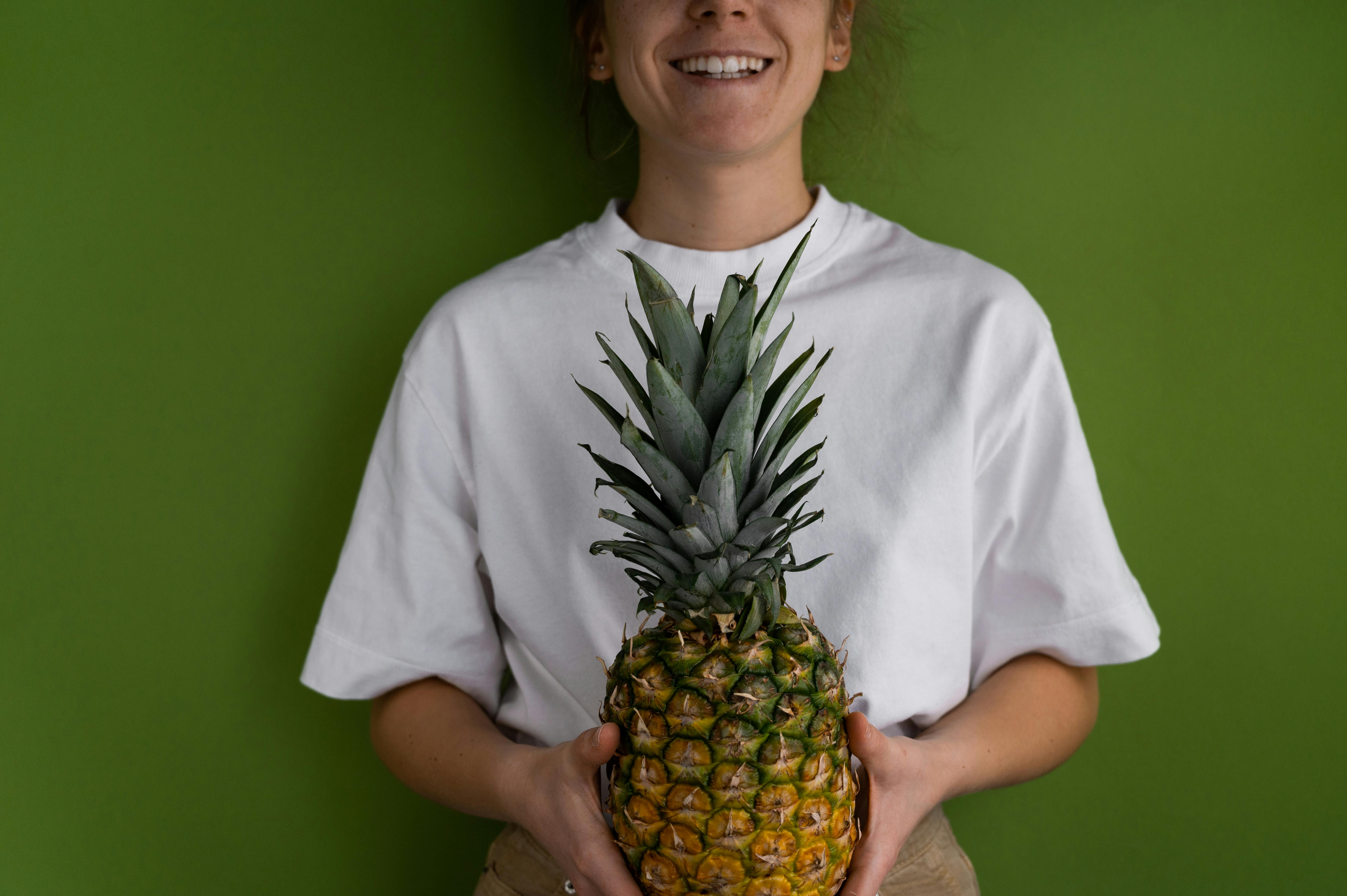 cheerful anonymous woman with pineapple