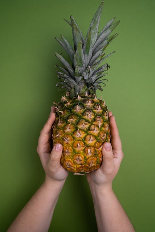 Faceless person with pineapple in hands