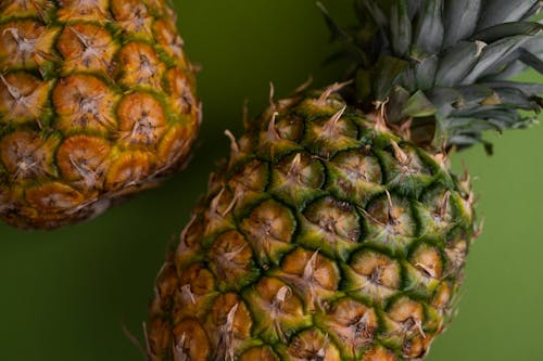 Ripe pineapples on green surface