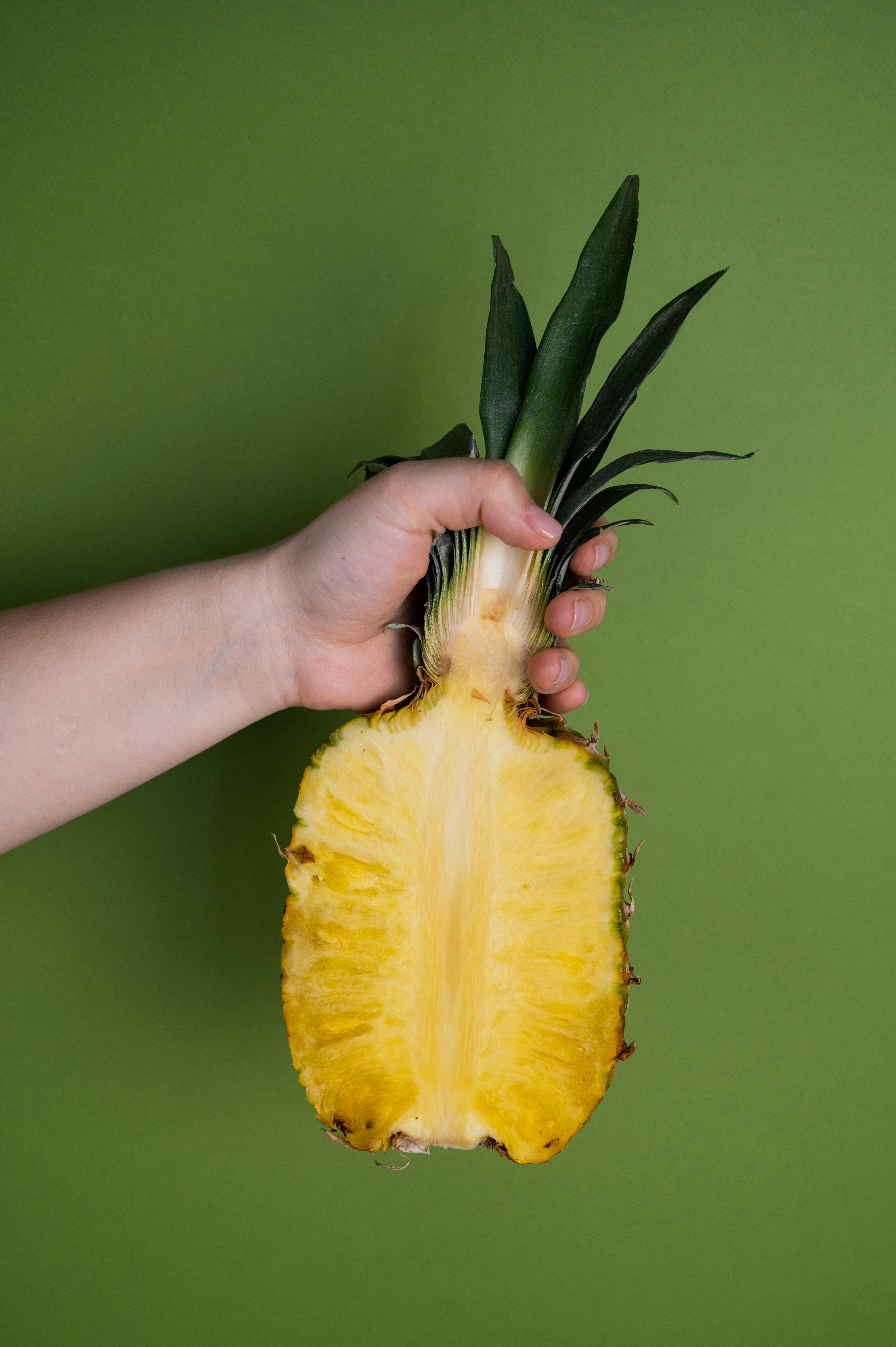 cut pineapple in hand of crop person