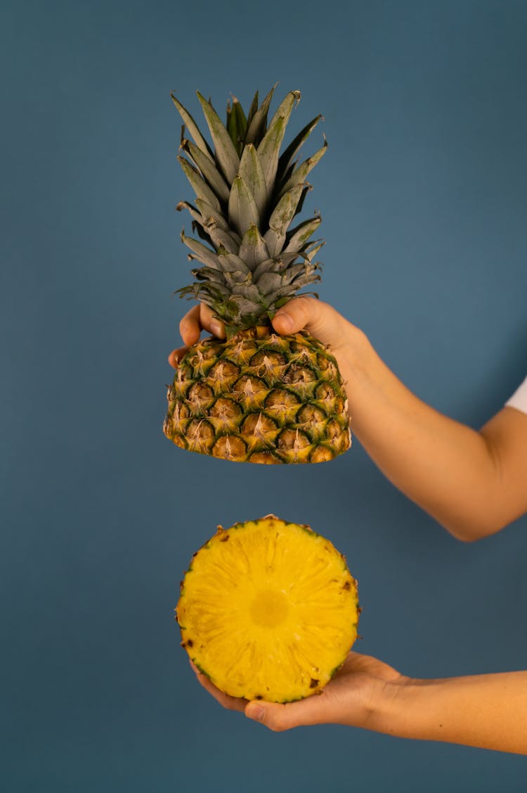 Crop Person Demonstrating Yummy Fresh Pineapple Halves