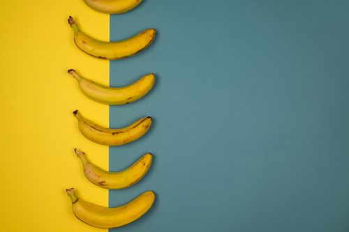 Free Overhead view of tasty ripe bananas with blots on yellow peel on two color background Stock Photo