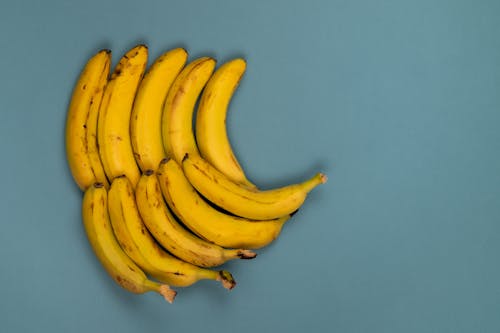 Rows of ripe bananas on blue background
