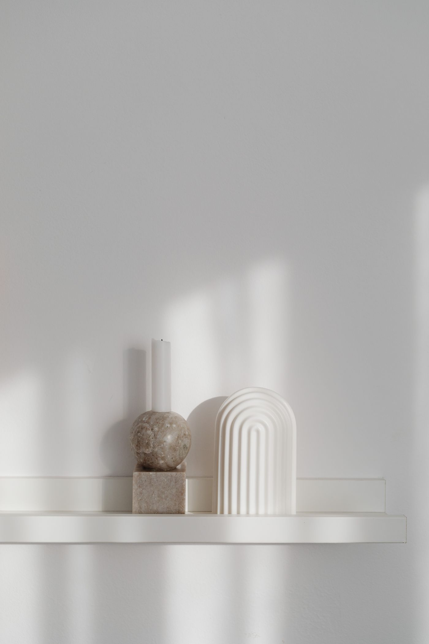 Sculptural candle holder displayed with abstract home objects in soft interior light