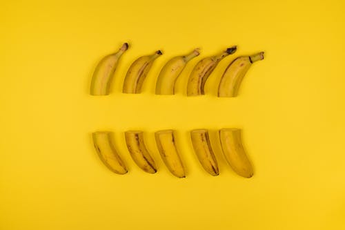 Yellow Banana Fruits Slice in Half Arranged on Yellow Background