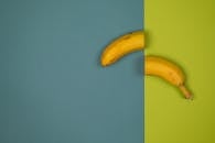 Ripe banana halves on two color background