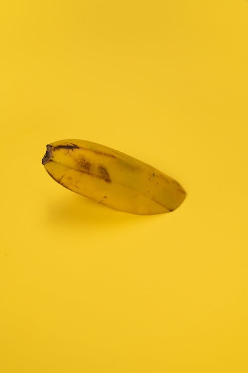 Fresh banana half with spots on peel