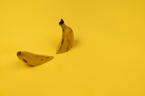 Delicious cut fresh banana on yellow background