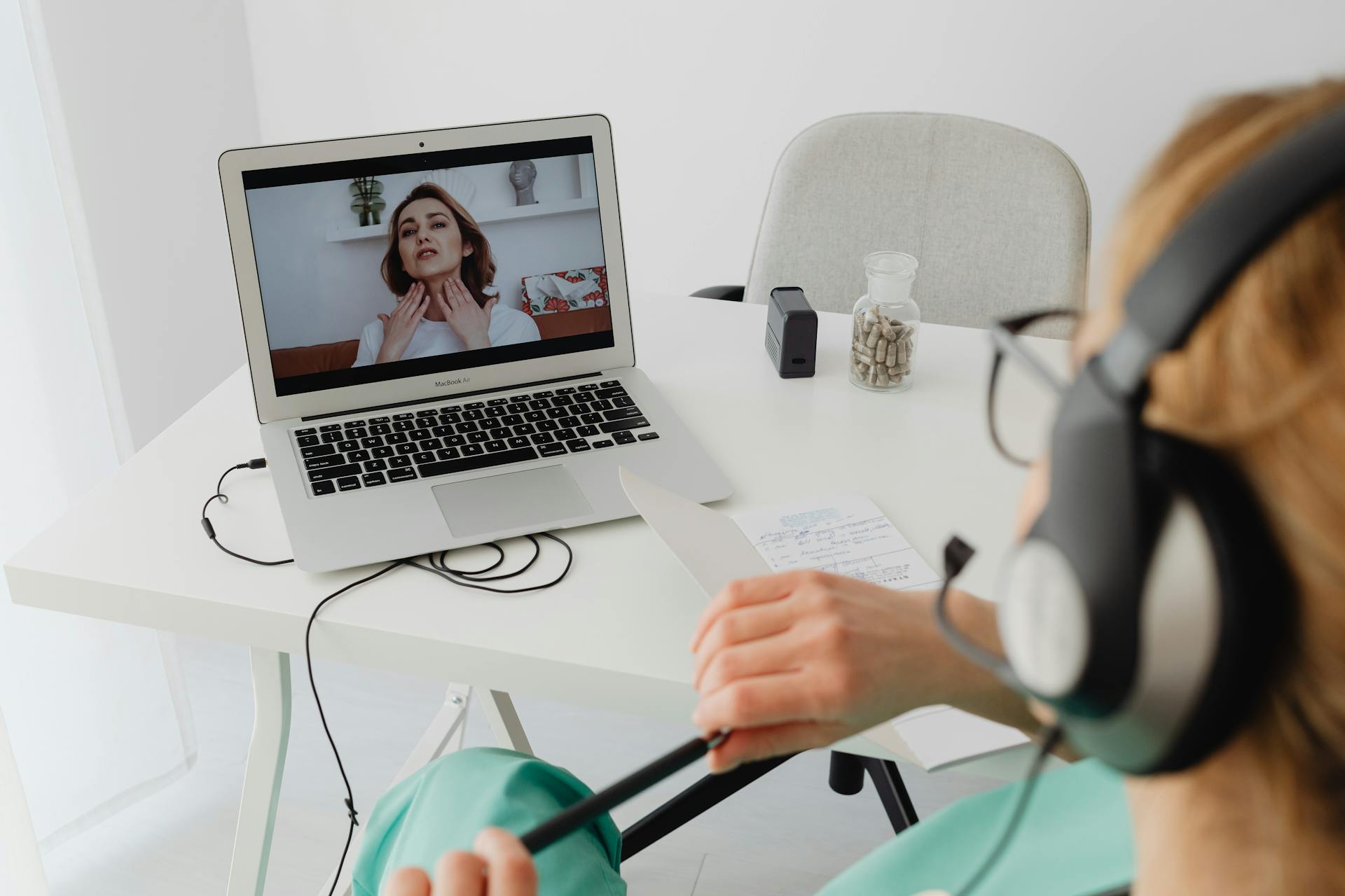 A healthcare professional video conferencing with a patient for an online consultation.