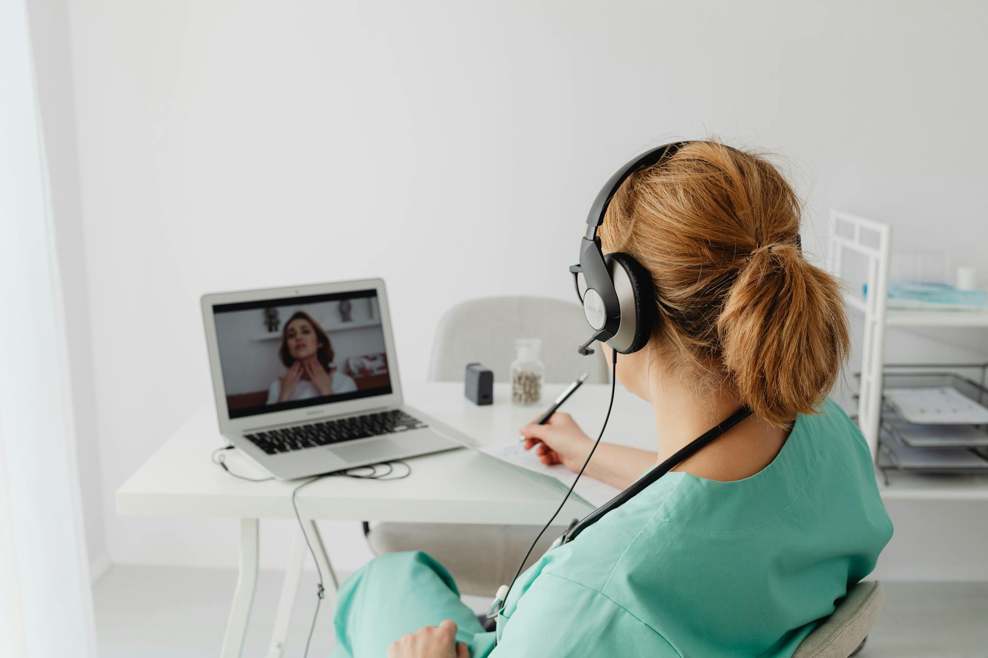 A female doctor conducts a virtual patient consultation via video call, showcasing telemedicine technology.