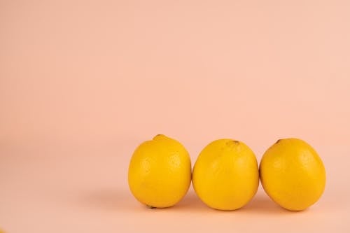 Fresh lemons in row on pastel background