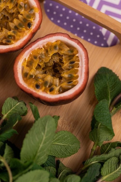 Cut fresh passion fruit with mint leaves on chopping board