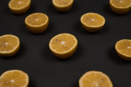 Free From above of ripe lemon halves with seeds and pleasant scent on blurred black background Stock Photo