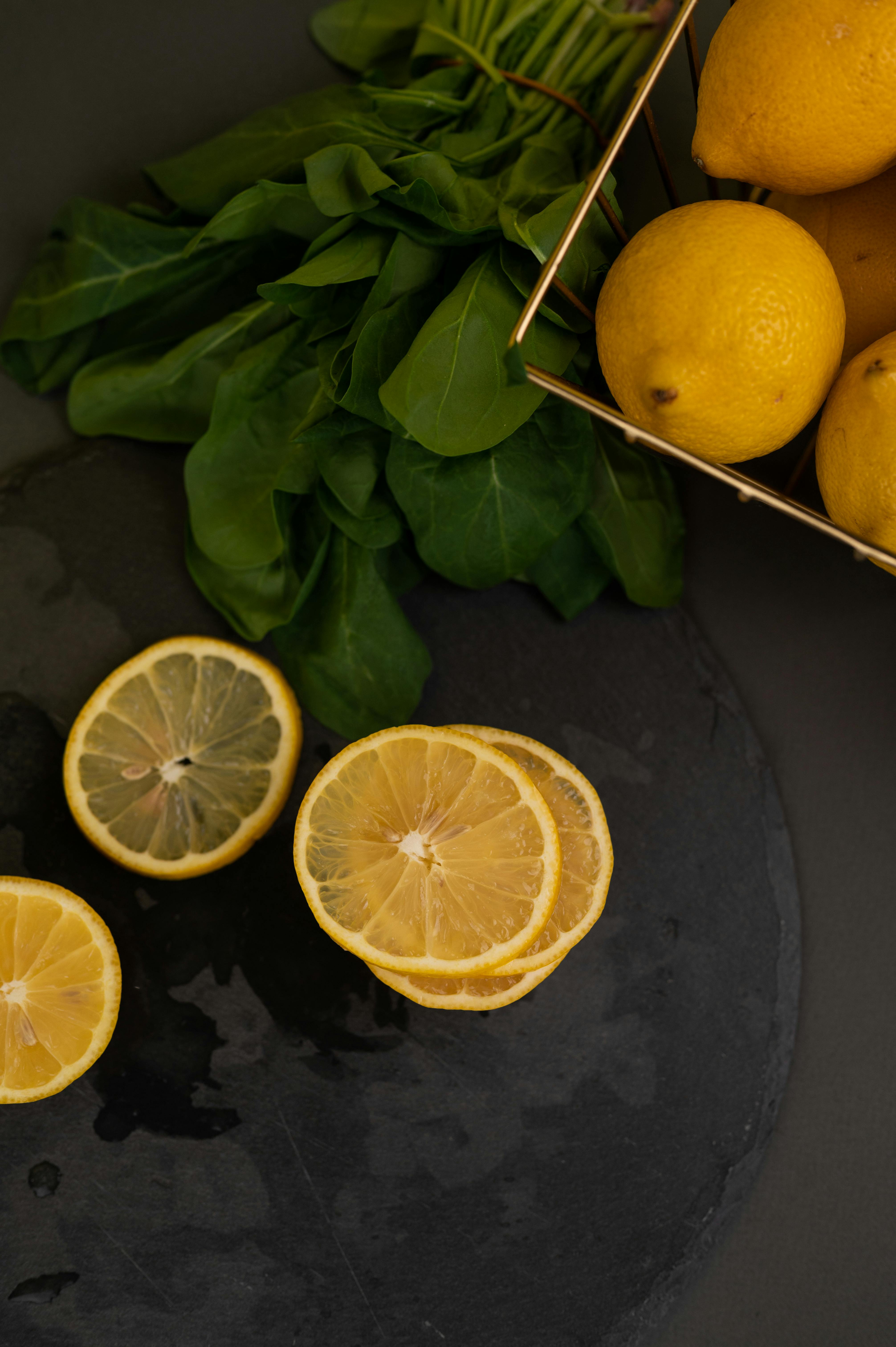 lemons and lemon slices near leaves