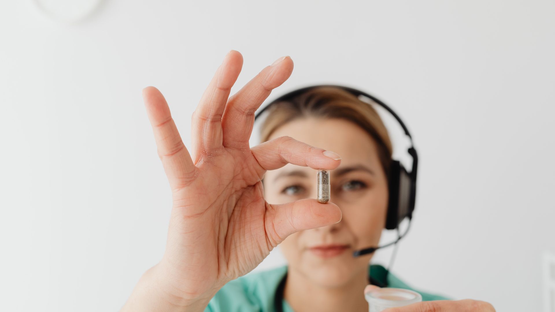 Modafinil Telehealth Prescription Online: Your Ultimate Guide A woman in a headset holds a capsule, symbolizing healthcare support — modafinil telehealth prescription online