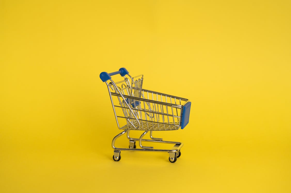 Empty shopping cart on yellow background · Free Stock Photo
