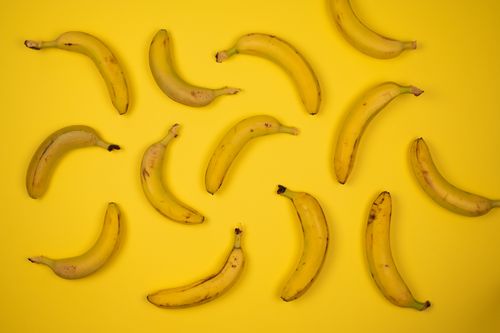 Free Top view of yummy ripe bananas placed at distance from each other on bright yellow background Stock Photo