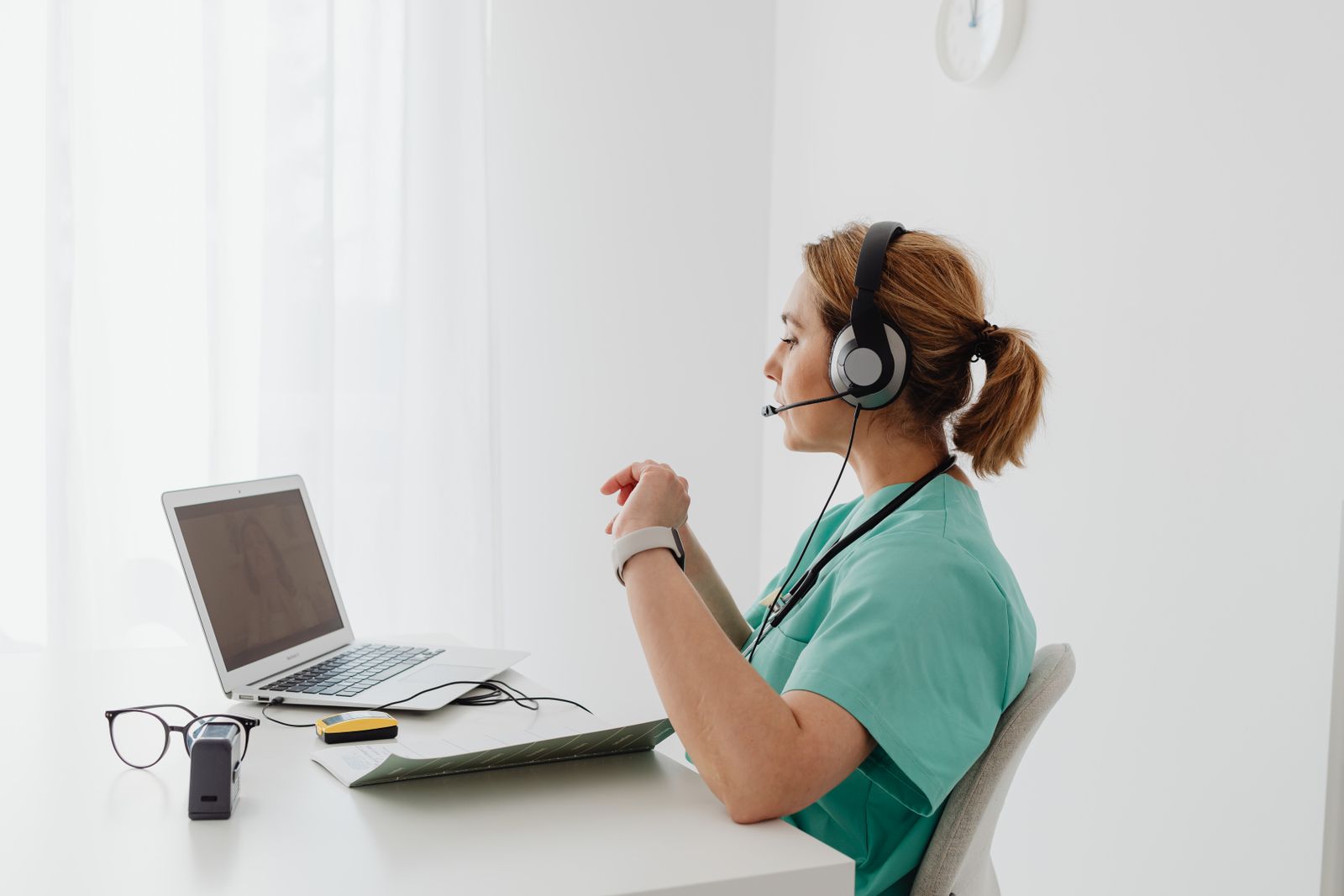 Mental health professional using a laptop and headset during a private telepsychiatry appointment