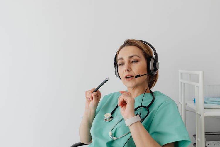 Woman Wearing Headset While Holding A Pen 