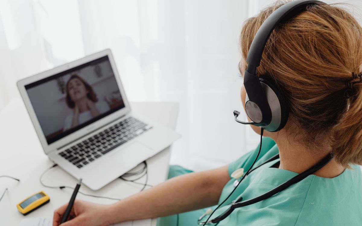 Medical professional consulting a patient online via laptop for telehealth services.
