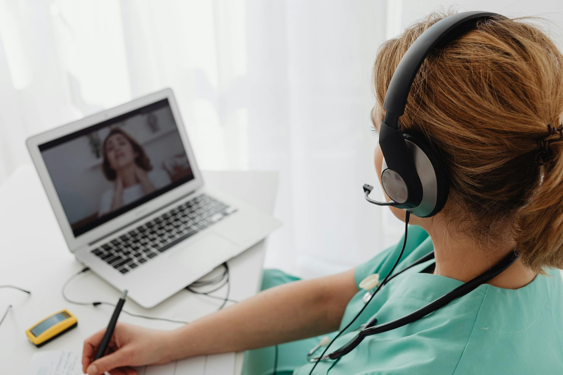 Medical professional consulting a patient online via laptop for telehealth services.