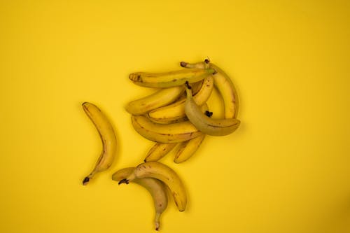 Free Bunch of yummy bananas on yellow backdrop Stock Photo