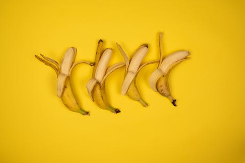 Row of fresh bananas on yellow background