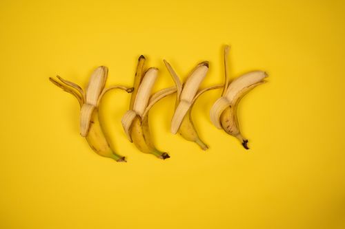 Free Top view backdrop of delicious whole sweet bananas with ripe flesh and spots on peel with stems Stock Photo