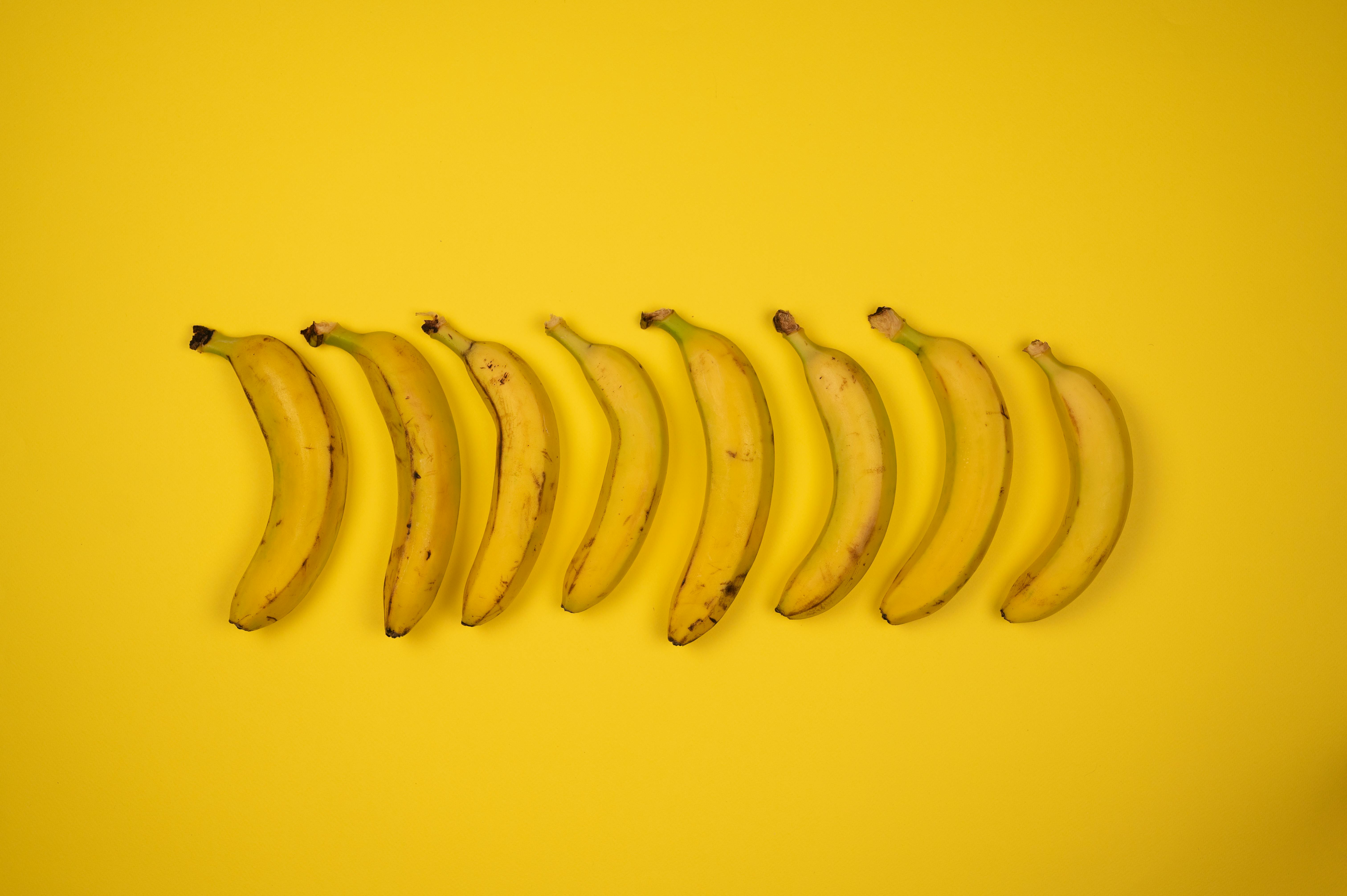 Backdrop of whole fresh bananas with stems · Free Stock Photo