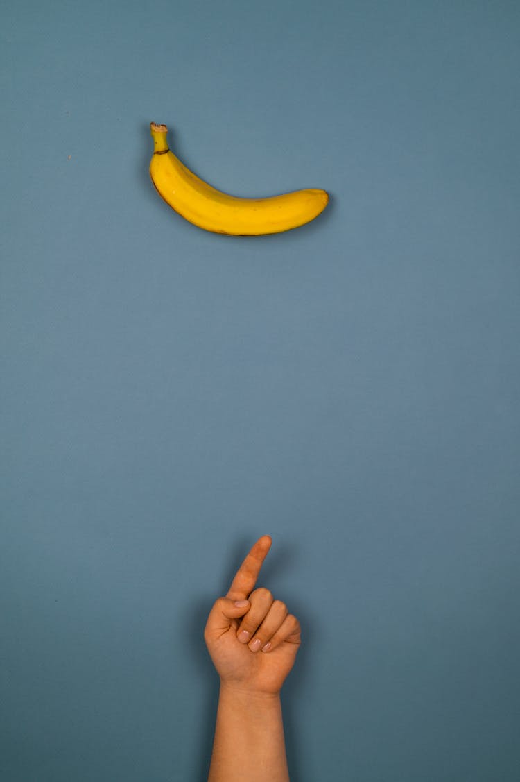 Crop Person Pointing Up Against Fresh Banana