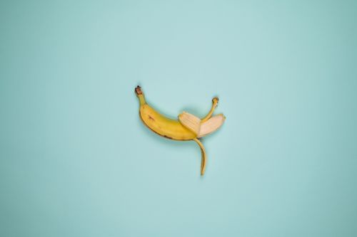 Free Top view backdrop of tasty whole banana with blots on yellow peel and curved stalk Stock Photo