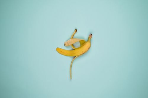 Free A vibrant banana peel on a pastel blue backdrop, perfect for fresh fruit concepts. Stock Photo