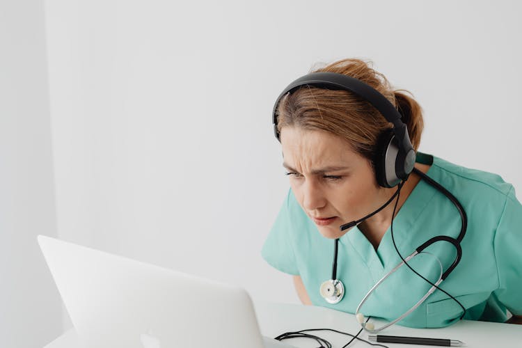 Woman Squinting In Front Of Laptop