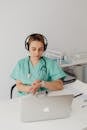 Woman in Teal Uniform Wearing Headphones Fixing Her Watch
