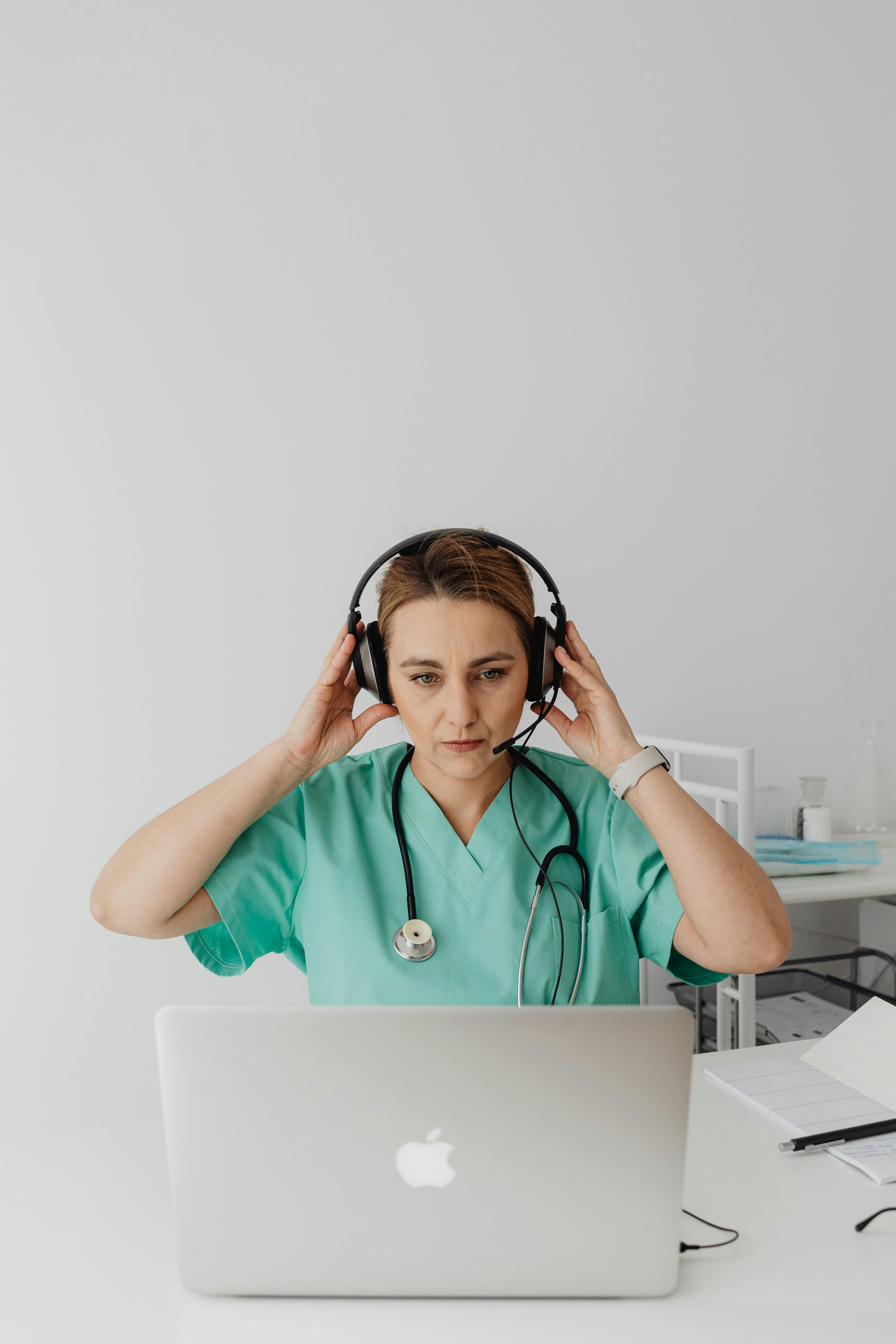 woman in teal scrub suit wearing headphones