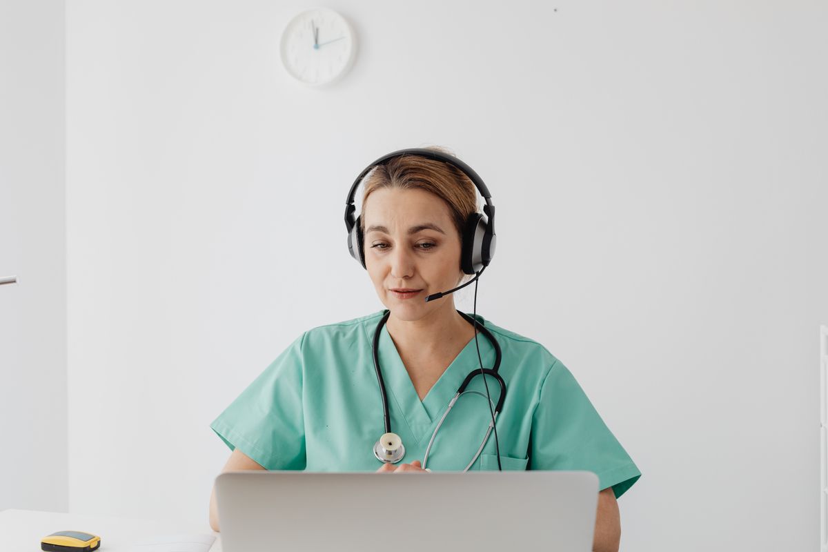 Female physician conducting a virtual Good Faith Exam consultation with a patient via laptop