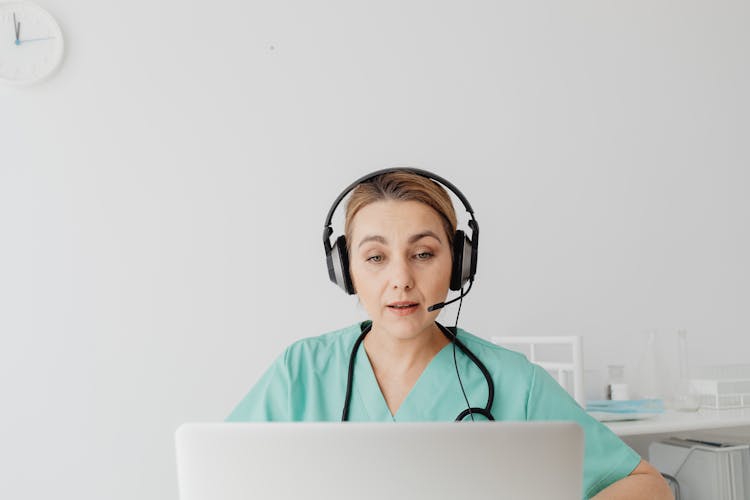 A Woman In Teal Shirt Talking While Wearing Headset