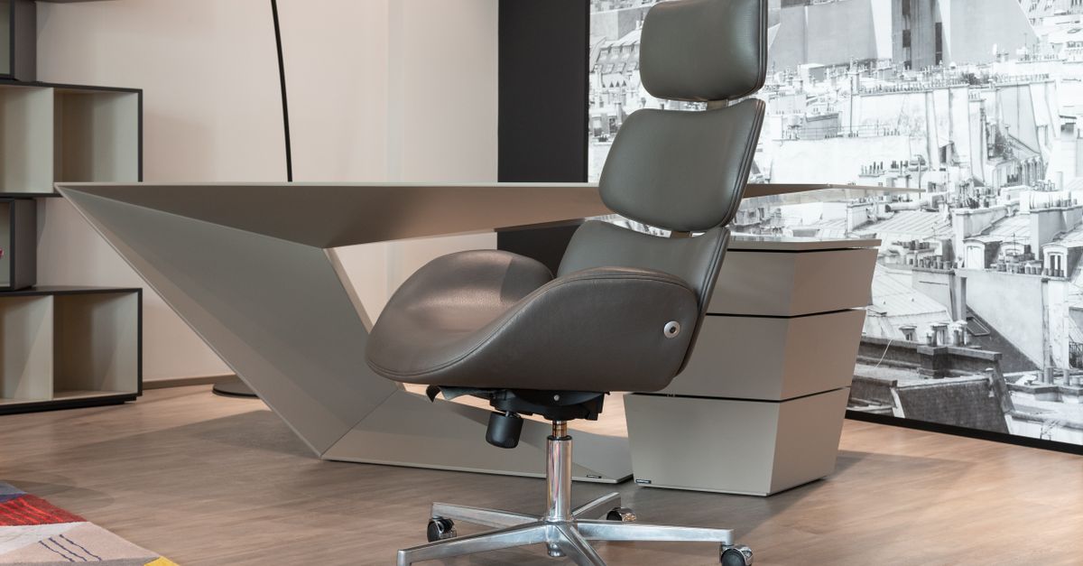 Sleek office setup with a designer chair and geometric desk in a modern workspace.