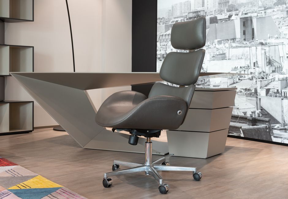 Sleek office setup with a designer chair and geometric desk in a modern workspace.