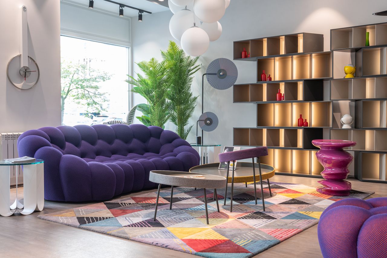 Eclectic living room with a purple sofa and mixed furniture styles