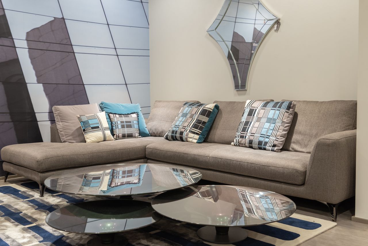 Gray corner sofa with symmetrical patterned and teal throw pillows