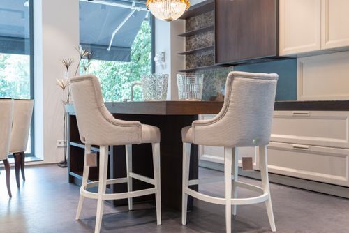 Free Interior of modern kitchen with table with white comfortable chairs near wooden cabinets and glass wall Stock Photo