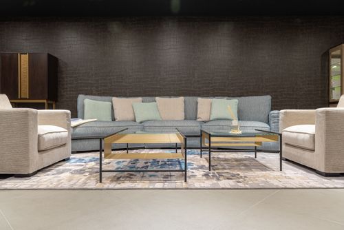 Free Comfortable gray sofa with colorful cushions and armchairs near tables on carpet in modern living room with dark wall Stock Photo